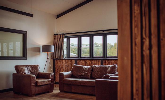 Three sofas under large windows on an upstairs mezzanine
